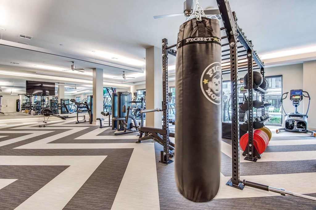 A gym with a punching bag and various exercise equipment.