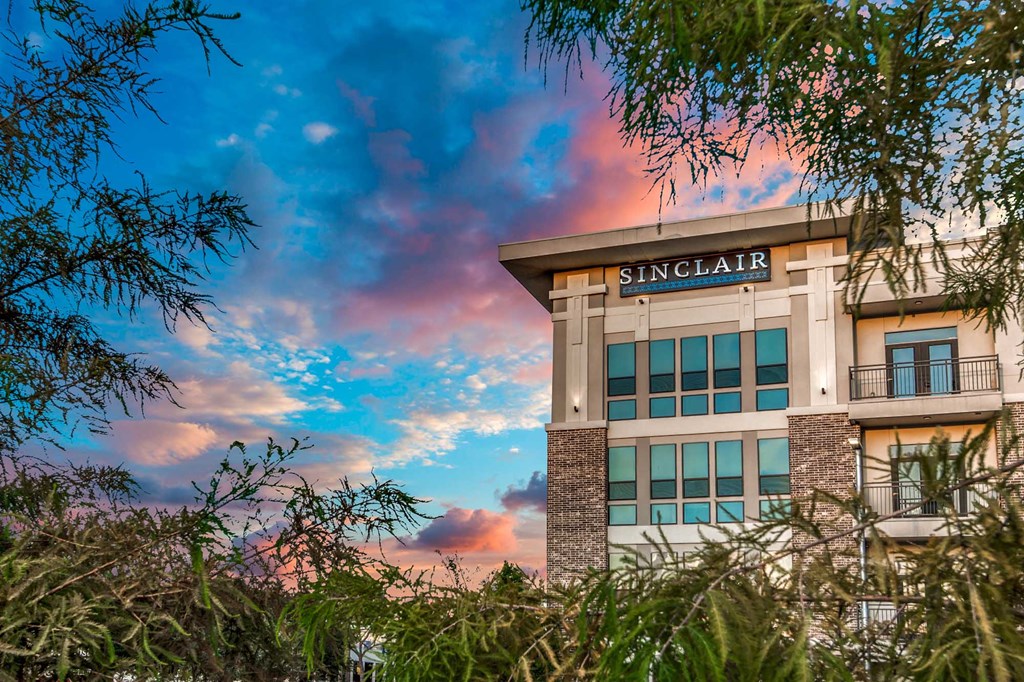 A building with the name Sinclair on it is surrounded by trees.