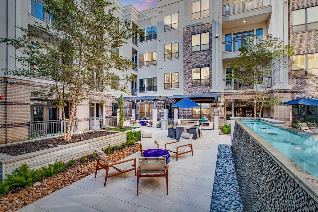 A pool and patio area in front of a building.