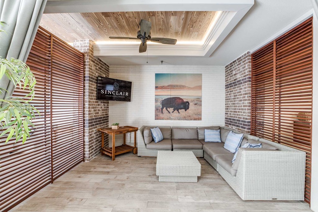 A living room with a sofa, a table, and a painting of a bison on the wall.