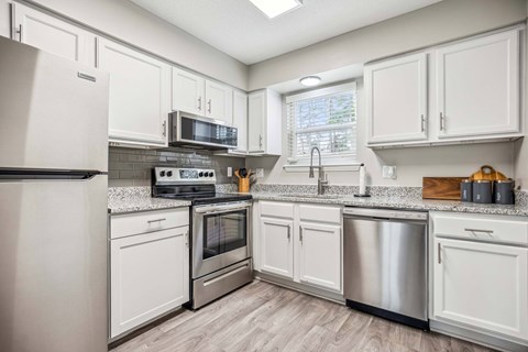 A kitchen with white cabinets and stainless steel appliances.