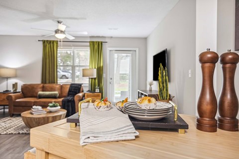 A modern dining room with a wooden table set for two.