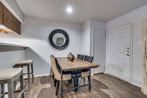 A dining room with a wooden table and chairs.