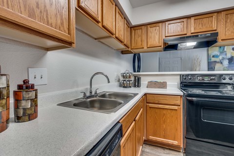 A kitchen with wooden cabinets and a black oven.