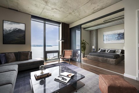 A modern living room with a large window overlooking the water.