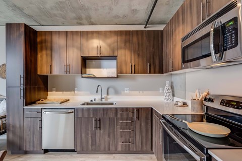 A modern kitchen with wooden cabinets and stainless steel appliances.