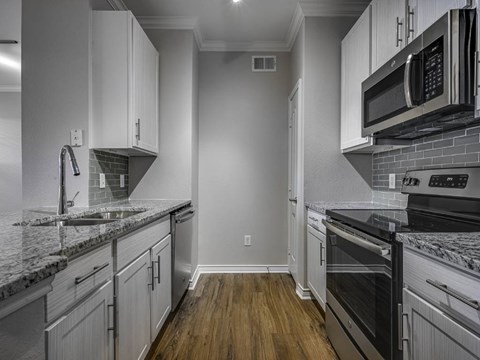 A kitchen with white cabinets and a black stove top oven.