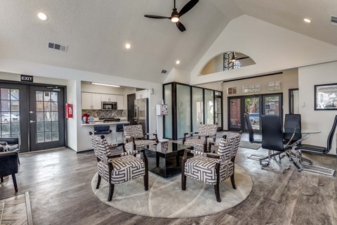 A modern living room with a glass table and striped chairs.