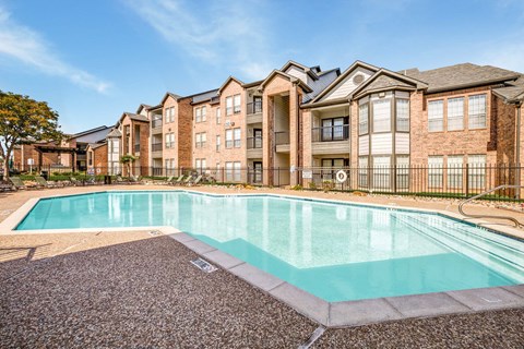 A large swimming pool in front of apartment buildings.