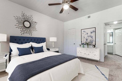 A bedroom with a large bed and a ceiling fan.