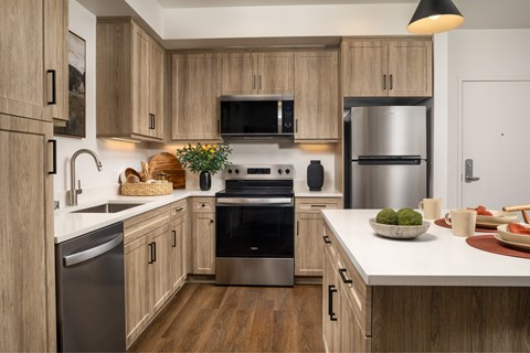 A modern kitchen with wooden cabinets and stainless steel appliances.