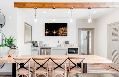 A modern kitchen with a wooden table and chairs.