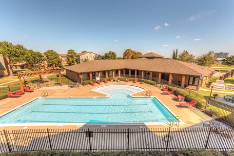 A large outdoor swimming pool surrounded by a black fence.