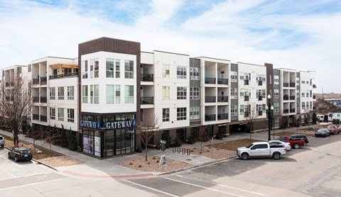 A white car is parked in front of a building with a sign that says "Gateway Gateway.".