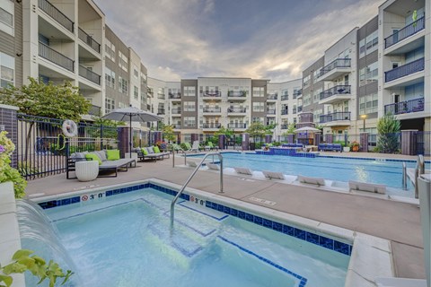 A swimming pool in a residential area surrounded by apartment buildings.