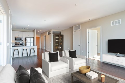 A modern living room with white furniture and a flat screen TV.