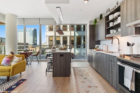 A modern kitchen with a yellow chair and a wooden floor.