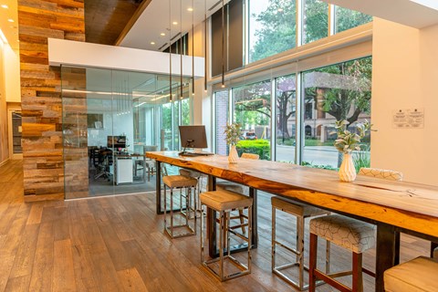 A modern kitchen with a long wooden island and stools.