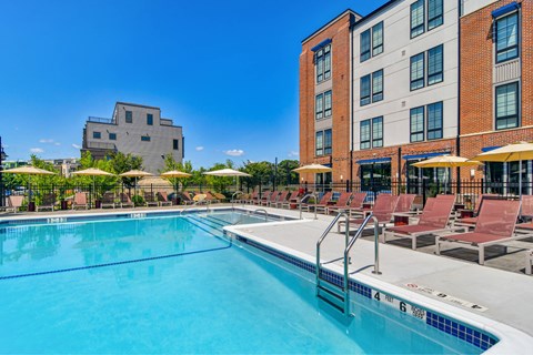 A large swimming pool with a building in the background.