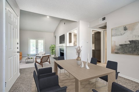 A dining room with a wooden table and chairs.