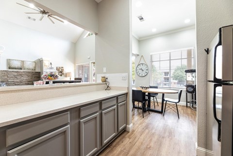 A kitchen with a refrigerator on the right side.