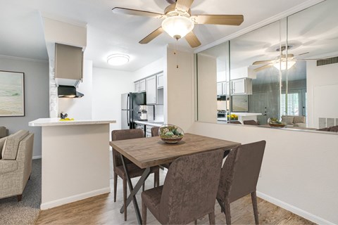 A dining room with a table and chairs.