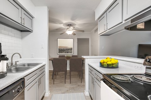 A kitchen with a table and chairs in the middle.