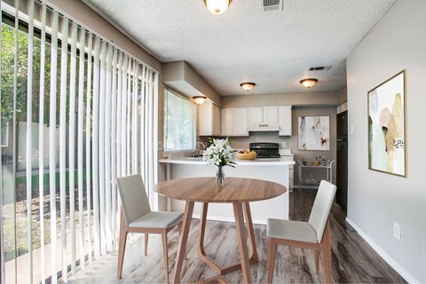 A dining room with a table and chairs.