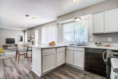 A kitchen with white cabinets and a black dishwasher.