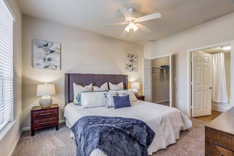 A bedroom with a large bed and a ceiling fan.