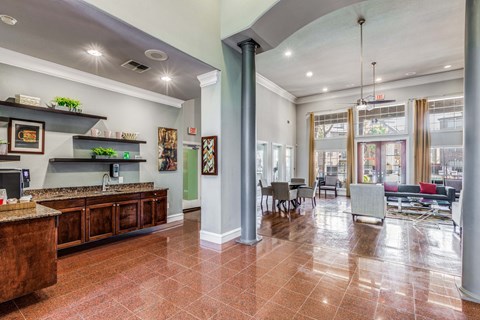 A kitchen area with a brown counter top and a dining area with a table and chairs.
