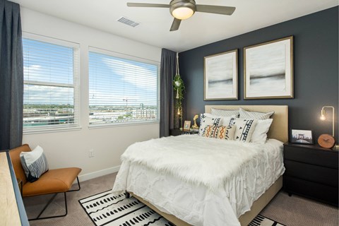 A bedroom with a large bed and a ceiling fan.