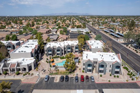 A bird's eye view of a residential area with houses and a swimming pool.