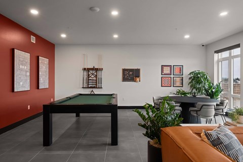 A room with a pool table and a couch.
