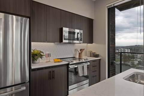 A modern kitchen with a stainless steel refrigerator and wooden cabinets.