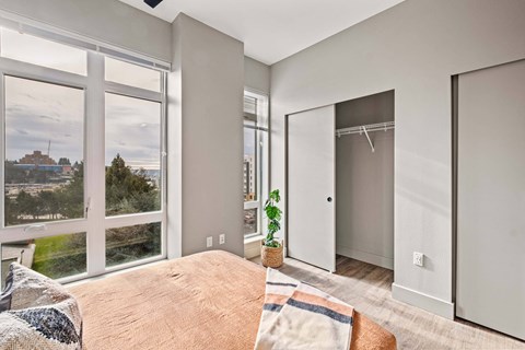 A bedroom with a large bed and a view of the city.