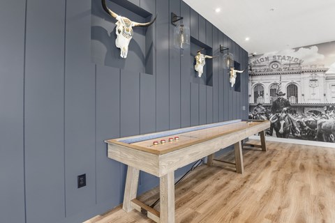 A pool table in a room with a cow skull on the wall.