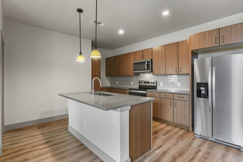 A modern kitchen with wooden cabinets and stainless steel appliances.