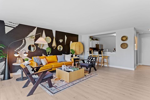 A living room with a yellow sofa and a wooden coffee table.
