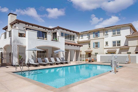 A large white house with a pool in front.