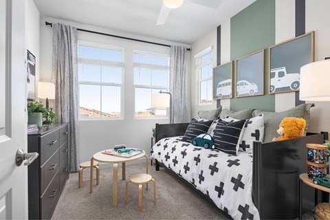 A bedroom with a bed, a table, and a window.
