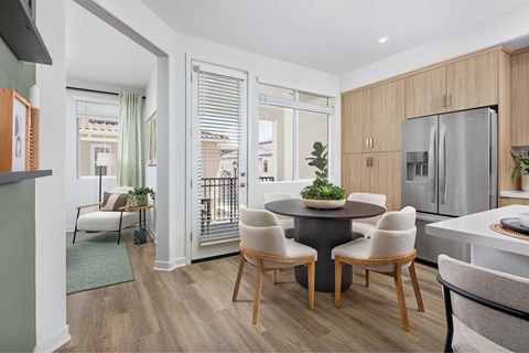 A modern kitchen with a dining table and chairs.