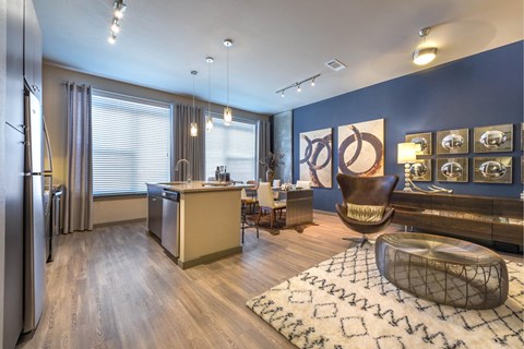 A modern kitchen with a refrigerator, sink, and a dining table with chairs.