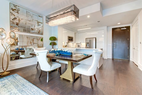 A modern dining room with a wooden table and white chairs.