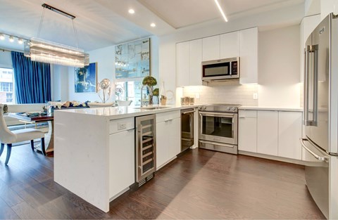 A modern kitchen with white cabinets and stainless steel appliances.