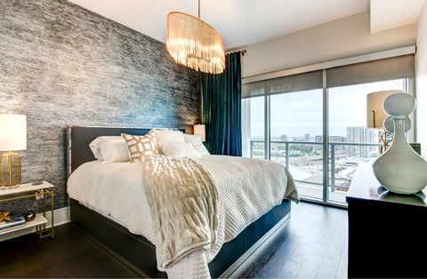 A bedroom with a large bed and a view of the city.