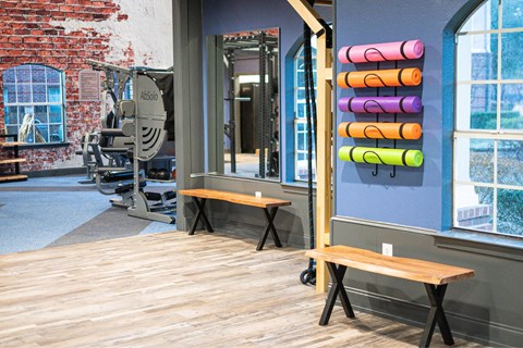 A room with a bench and a wall with a row of colorful objects.