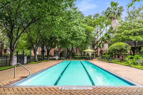 A pool surrounded by trees and a fence with a sign that says 4 FT NO DIVING.