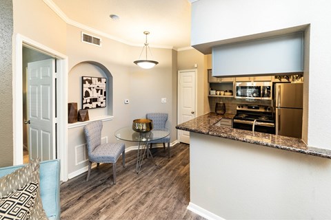 A kitchen area with a table and chairs.