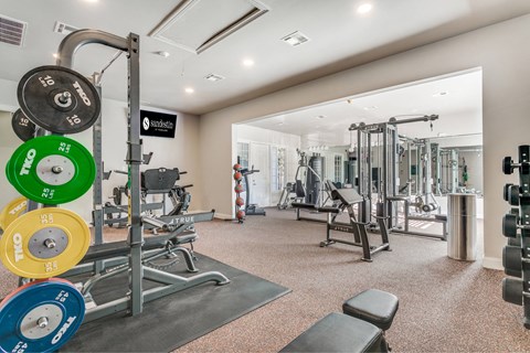 A gym with a variety of equipment including weights and machines.
